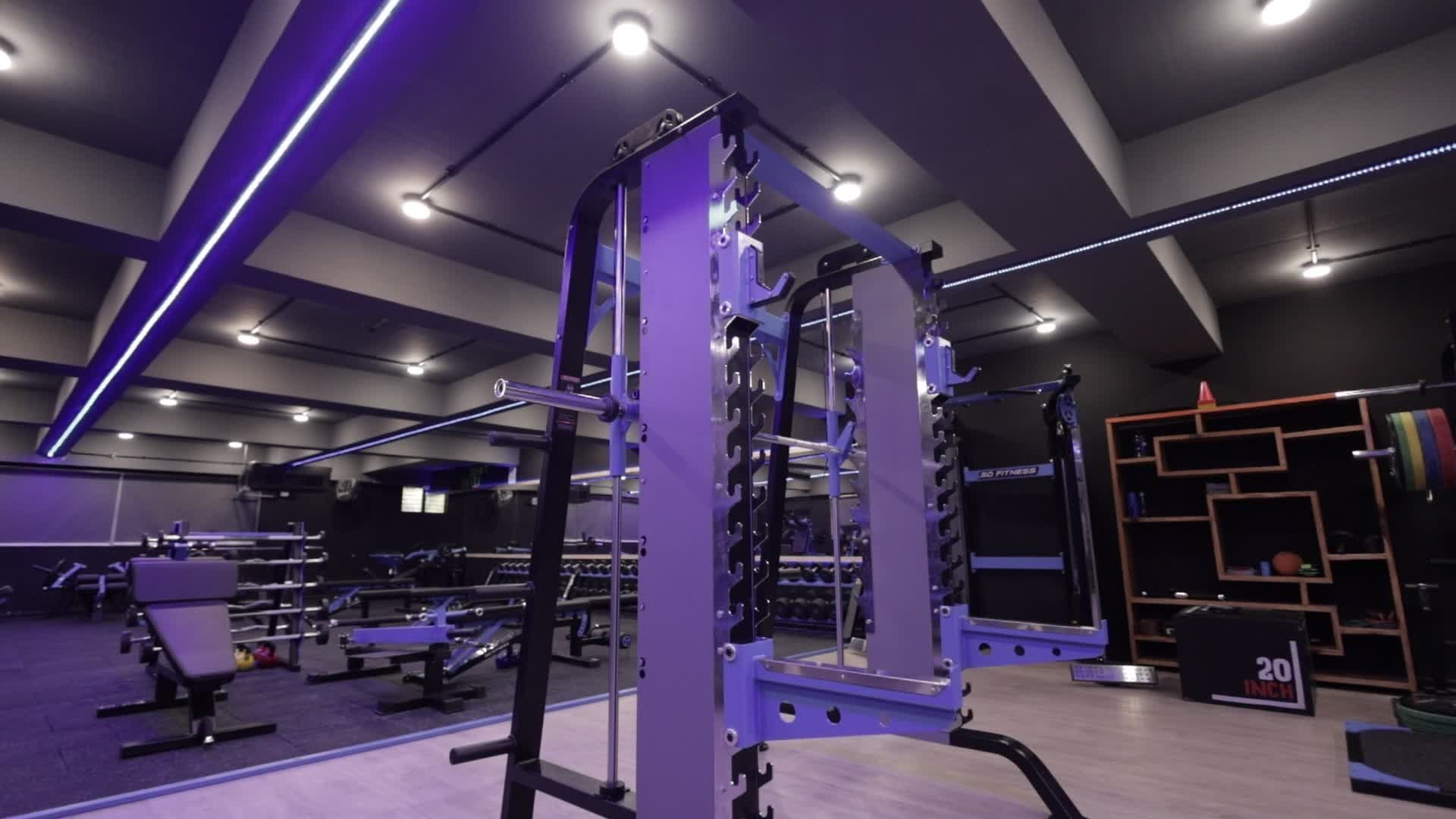 Academia moderna com equipamentos de treino e iluminação colorida